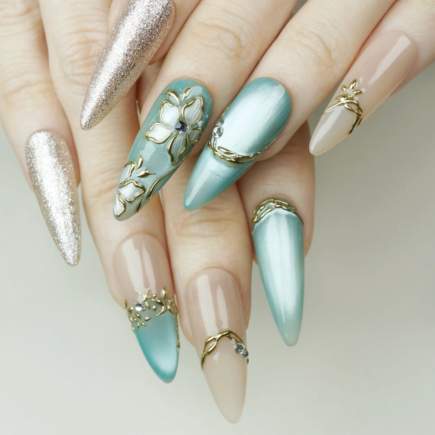 Tidal Heirloom press-on nails on display showing the full seafoam blue and antique gold nail art collection – Donailsart