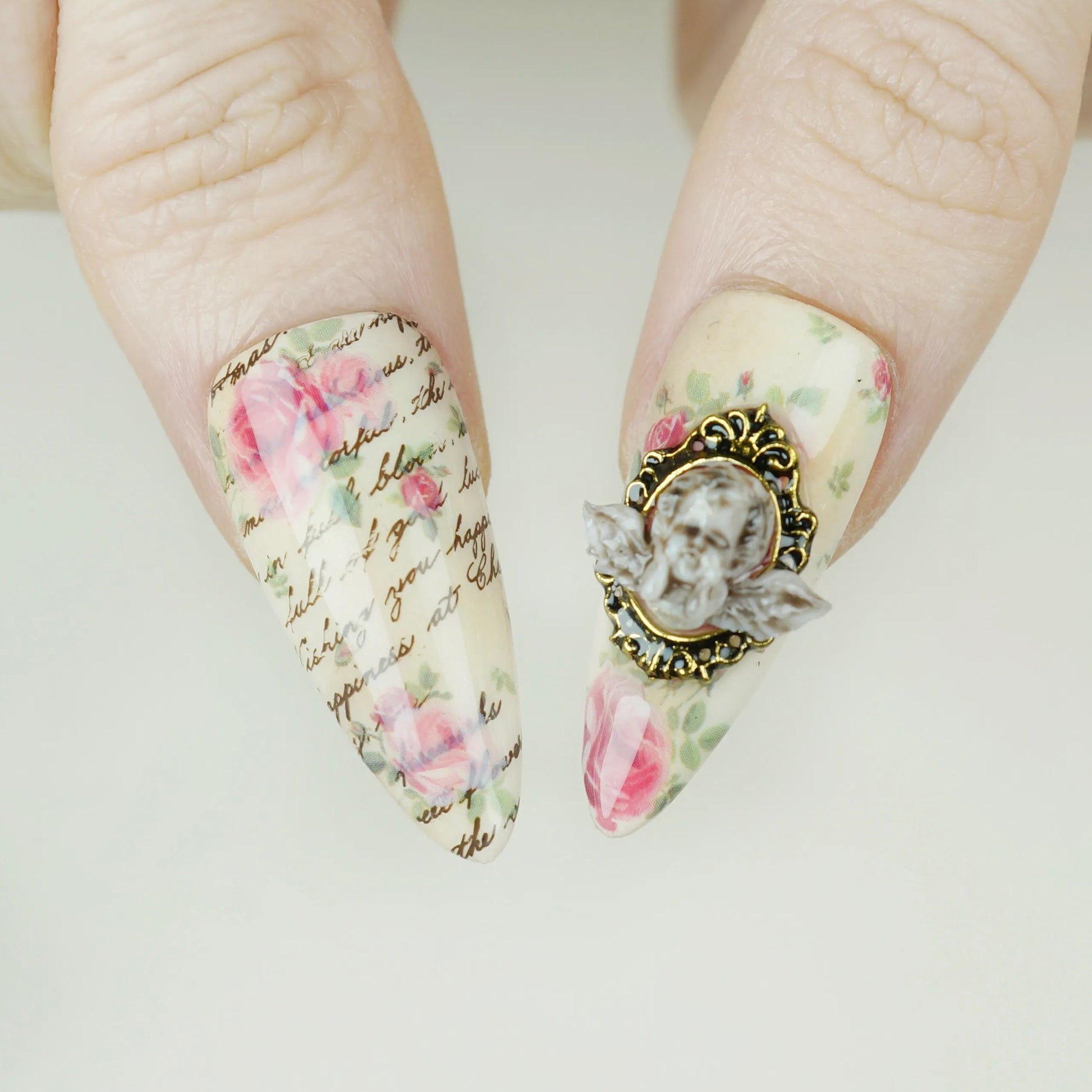 Cherub Relique close-up detail showing sculpted cherub cameo accent and gold frame on a blush shimmer nail – Donailsart