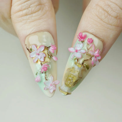 Garden Reverie close-up detail showing sculpted sakura blossom flowers and gold ornamental accents on a soft jade nail – Donailsart