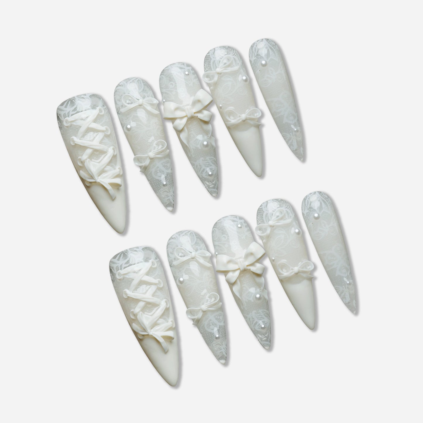 Ivory Keepsake press-on nail set by Donailsart – milky ivory nails with delicate lace patterns, glassy finish, sculpted bows, and tiny pearl accents