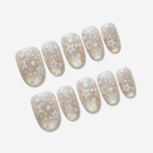 B5 | Ivory Lumen press-on nail set by Donailsart – sheer ivory base nails with warm gold shimmer and delicate star-like floating patterns