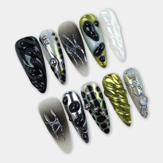 Futuristic press-on nails with black chrome details, 3D blobs, metallic gradients, and abstract insect-inspired art.