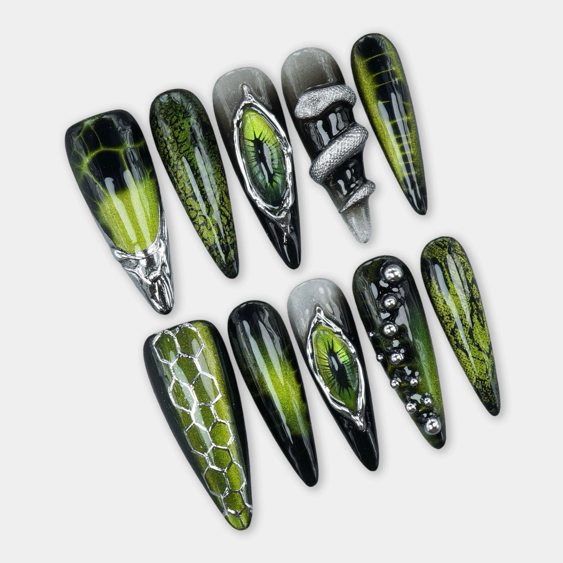 Cat-eye nails design with green magnetic shimmer, reptilian eye accents, and snake-scale textures by Donailsart