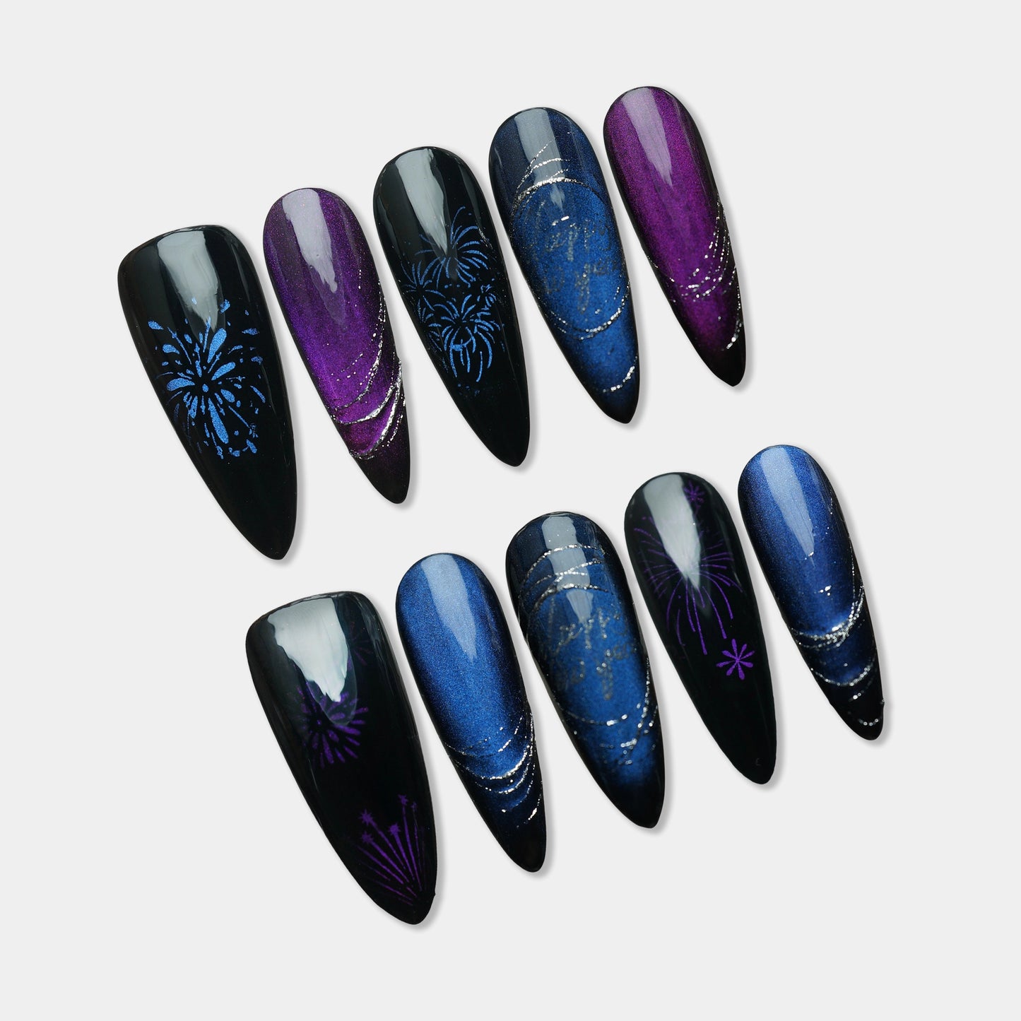Long black and blue cat-eye press-on nails with purple firework details and glossy finish.