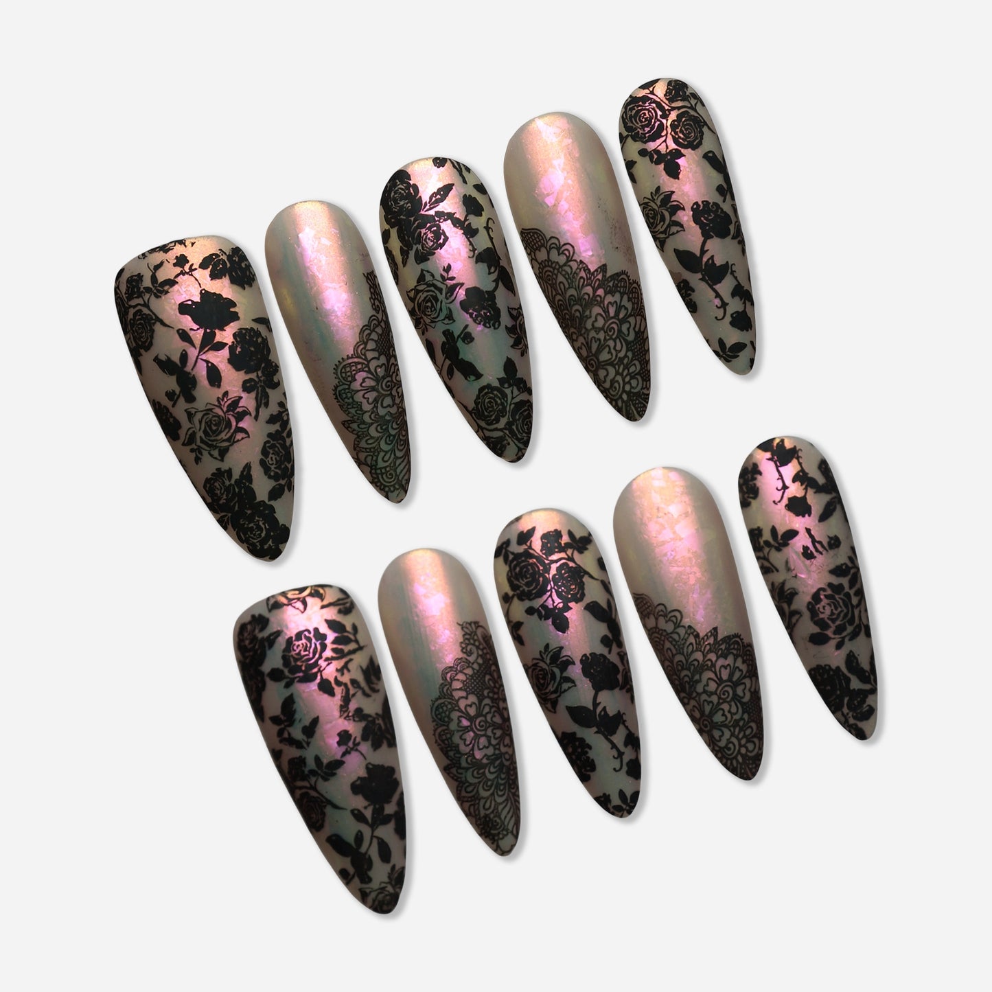 Opaline Veil press-on nail set by Donailsart – luminous pearlescent base nails shifting pink to champagne with intricate black floral lace overlay details
