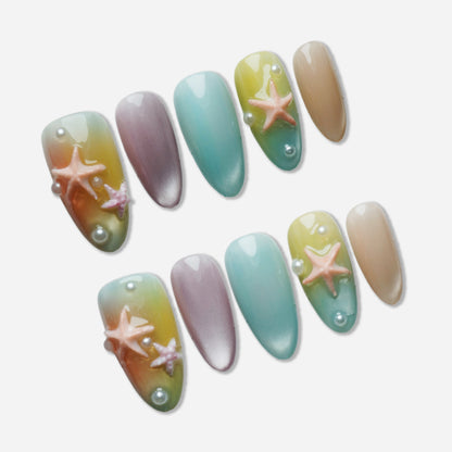 B3 | Pastel Sunset press-on nail set by Donailsart – dreamy pastel gradient nails shifting from warm sunset tones to cool ocean blues with starfish and pearl shimmer accents