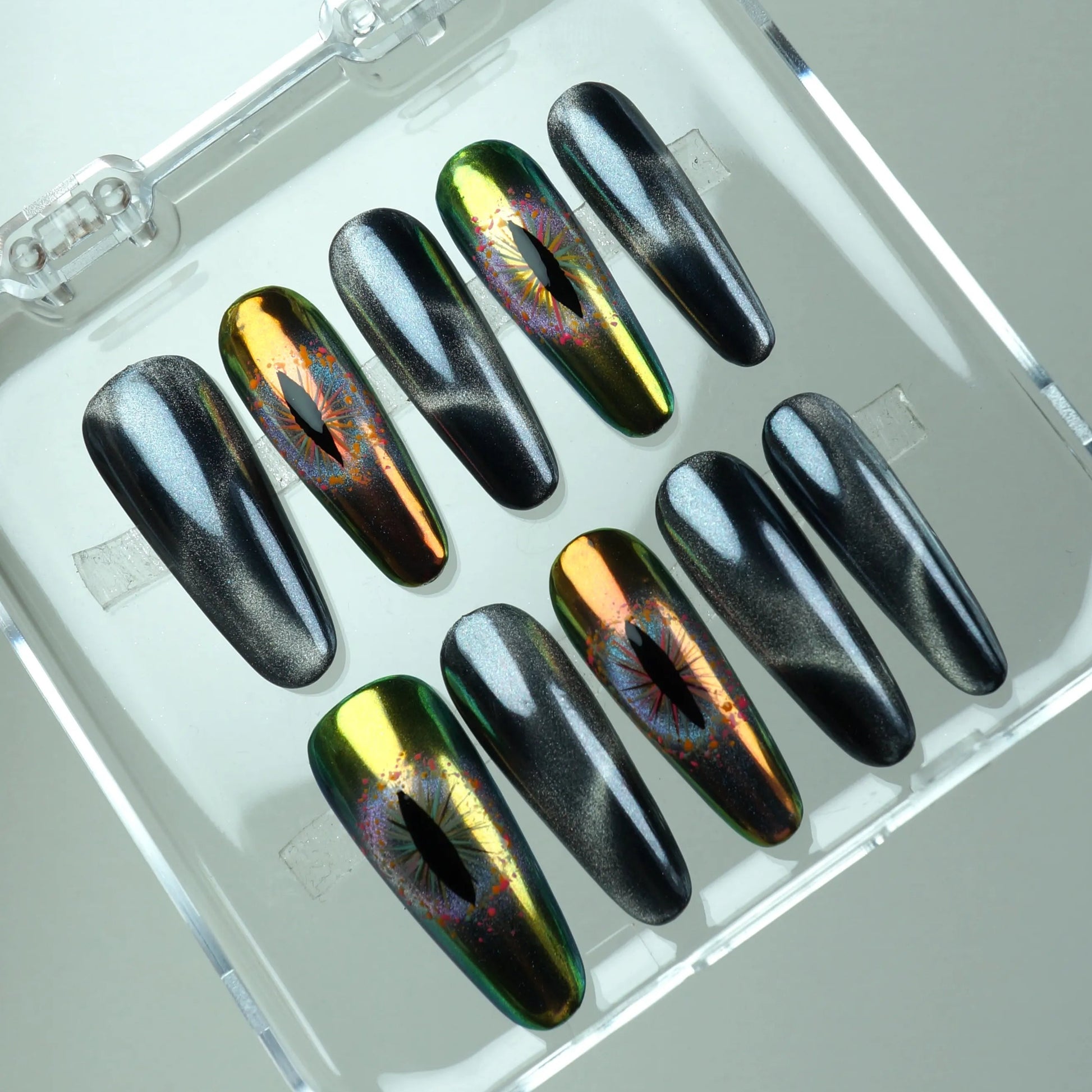 Press-on nails featuring black cat-eye magnetic shimmer and holographic reptile-eye designs in green and gold chrome by Donailsart

