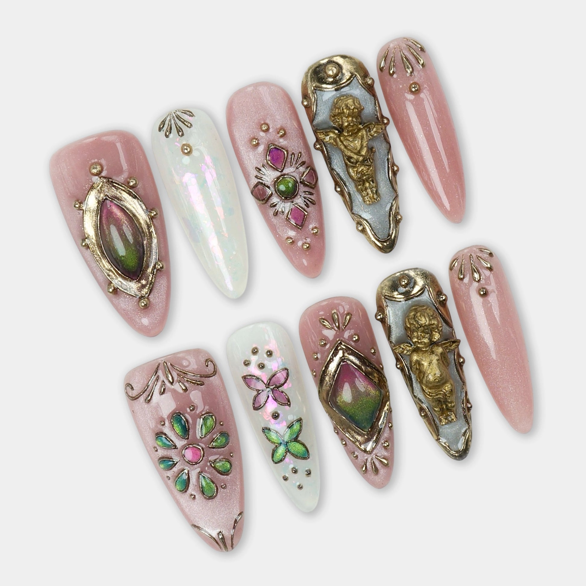 Elegant press-on nails with blush pink base, embellished with vintage gold angel charms, iridescent gems, and intricate floral and butterfly accents.