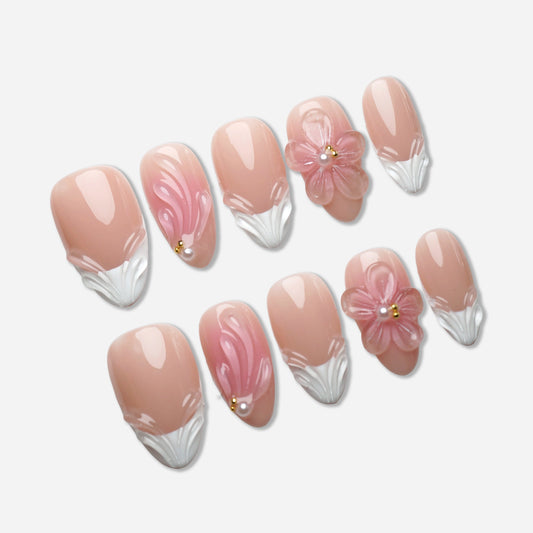 A17 | Rosy press-on nail set by Donailsart – natural nude base nails with gentle pink gradients, sculpted floral accents, and pearl embellishments