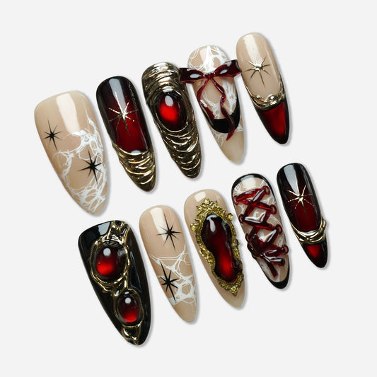 Royal Ruin press-on nail set by Donailsart – deep crimson chrome nails with sculpted gold details, corset lacing, and ribbon accents