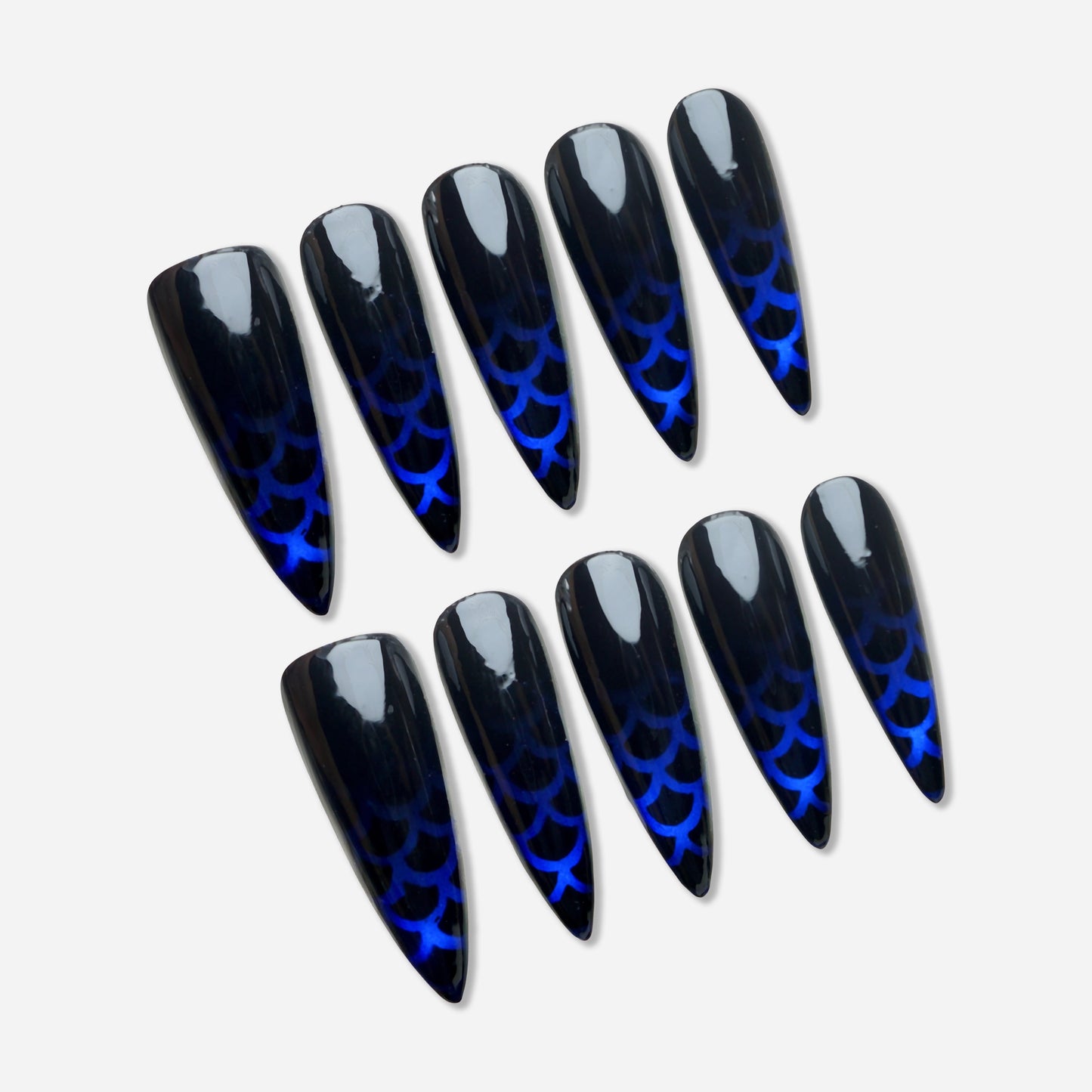 Siren Scale press-on nail set by Donailsart – deep black gloss nails with glowing cobalt blue mermaid scale patterns and reflective layered finish