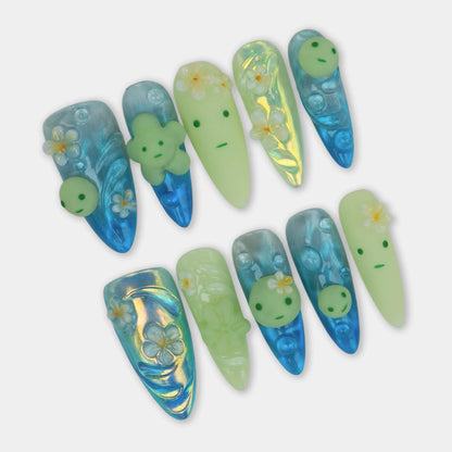 Cute smiski nails with translucent blue shimmer, 3D Smiski-inspired faces, and tropical flower details