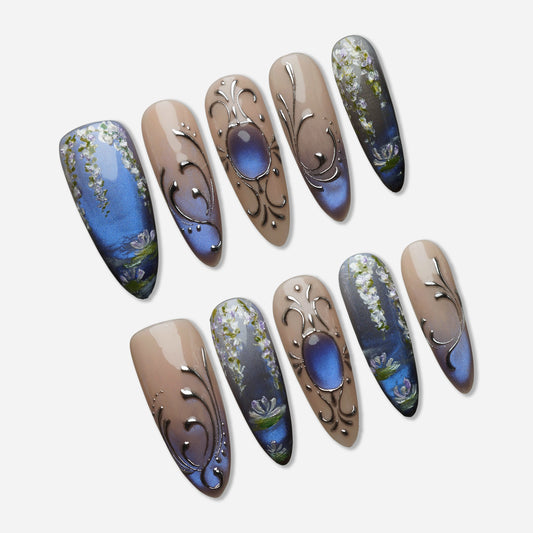 Velour Relic press-on nail set by Donailsart – muted nude nails with deep blue-violet gradient, fine chrome line details, and antique-inspired floral accents