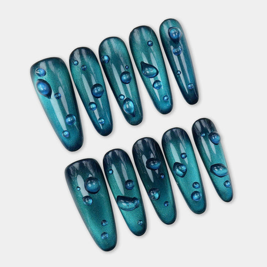 Dark blue cat eye gel nails with realistic water droplet accents, shimmering under light