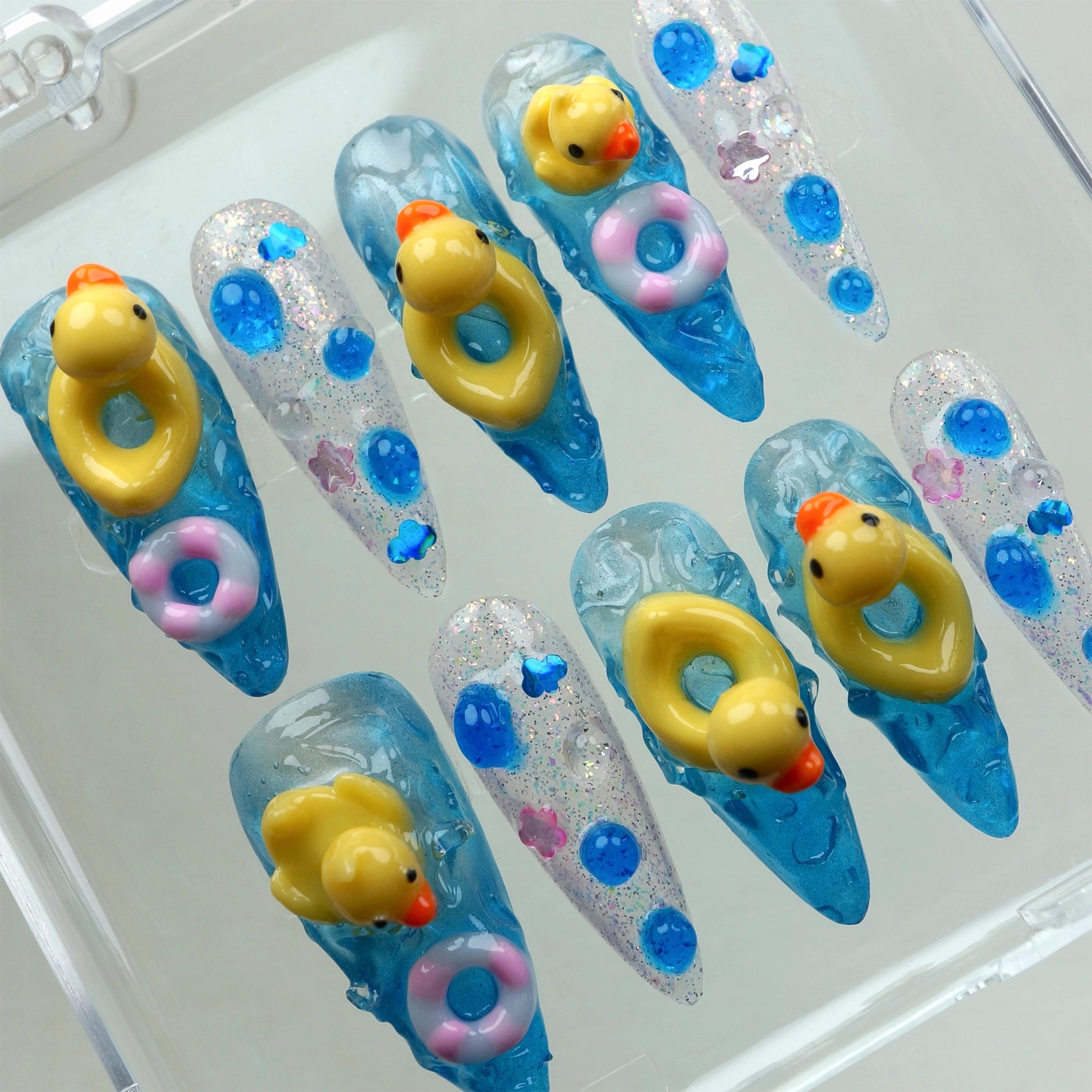 Handcrafted funny press-on nails with floating rubber duck and floatie designs for a fun summer look