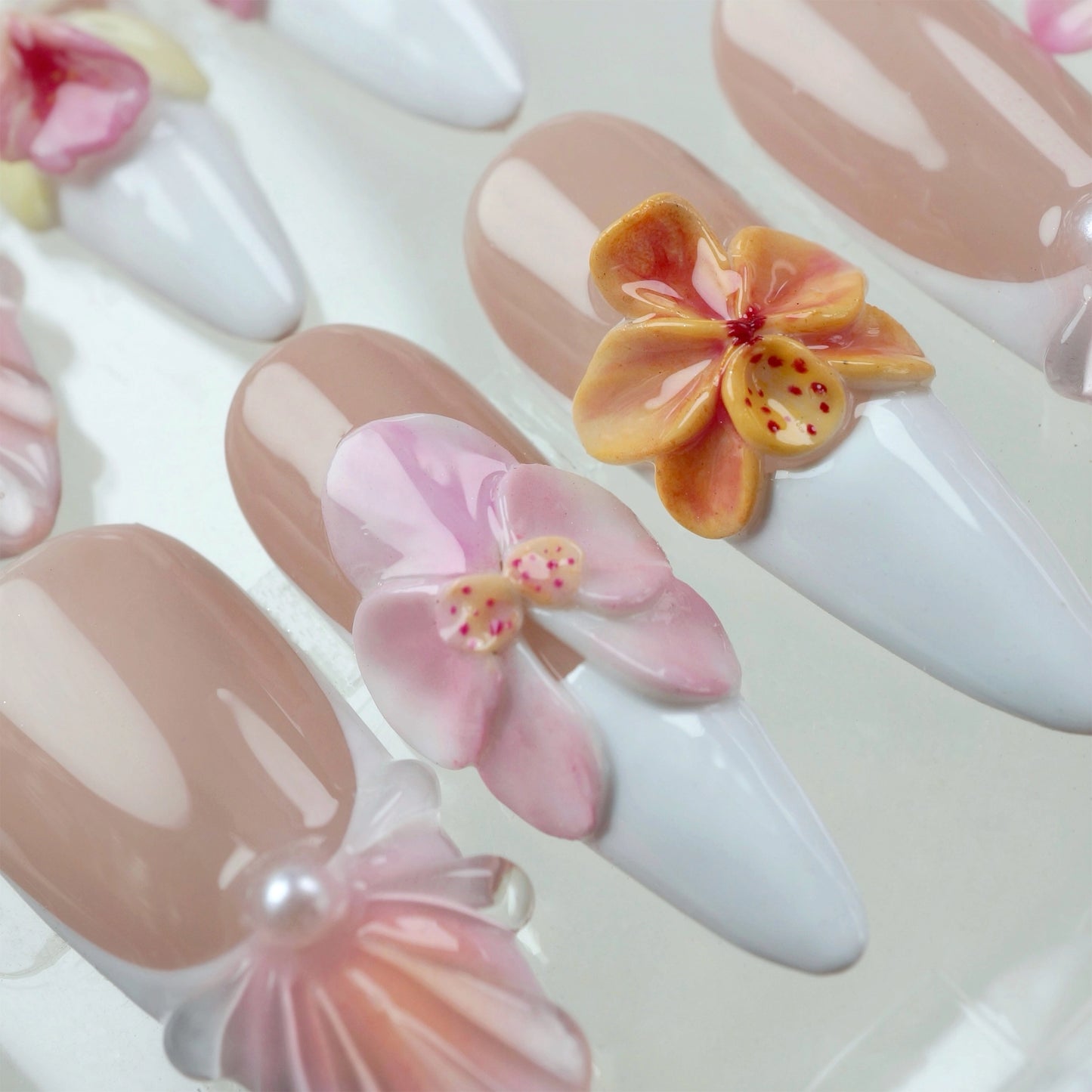 Elegant flower nails with sculpted blooms and seashell textures, combining soft colors and classic white tips