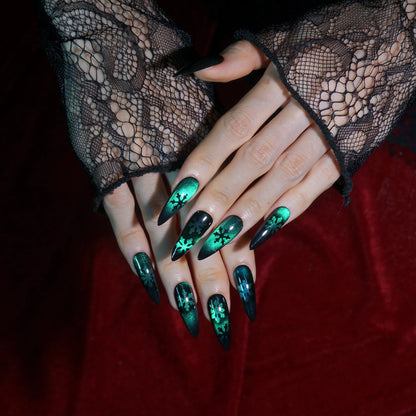 Frost Veil emerald cat-eye stiletto press-on nails with black snowflake art, full set worn on hand