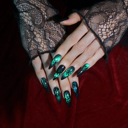 Frost Veil emerald cat-eye stiletto press-on nails with black snowflake art, full set worn on hand