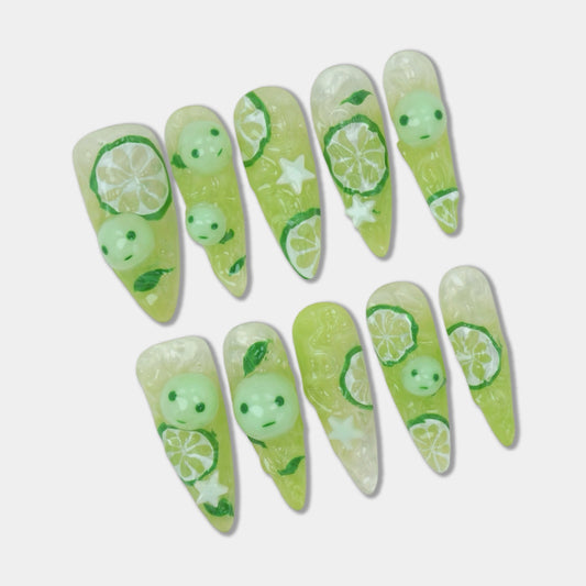 Glow-in-the-dark smiski press-on nails from Donailsart with 3D lemon slices, jelly texture, and playful green smiski characters