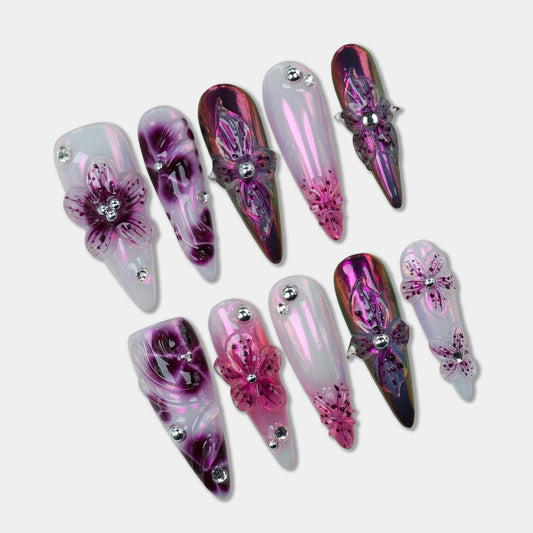 Glamorous flower design nails with iridescent chrome finishes and 3D purple blossoms accented by silver studs